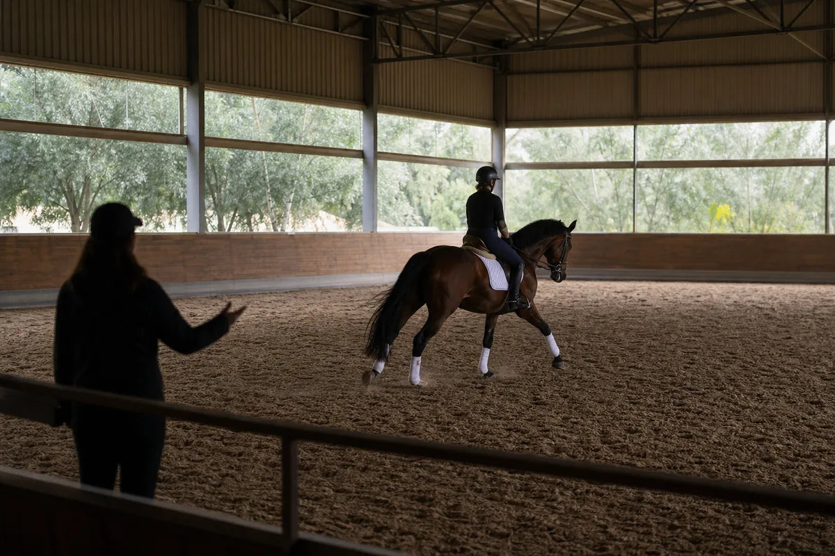 Moniteur d’équitation encadrant un cours dans un manège
